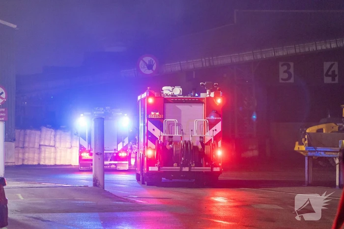 Zwarte rookpluimen boven havengebied door grote brand
