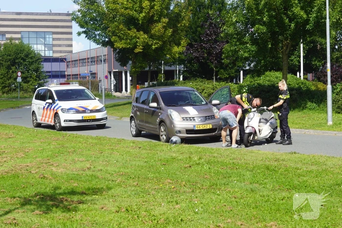 Automobilist en scooterrijder in botsing
