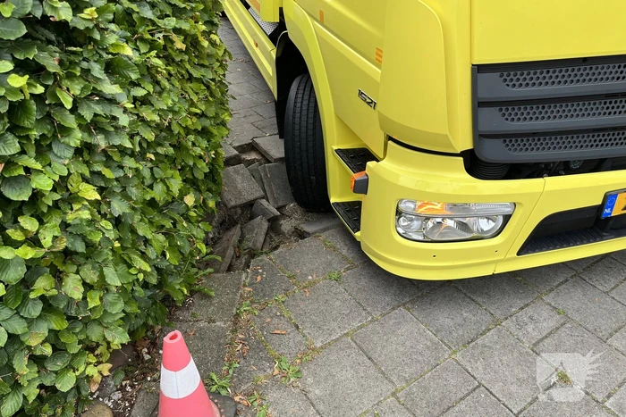 Vrachtwagen zakt weg in stoep