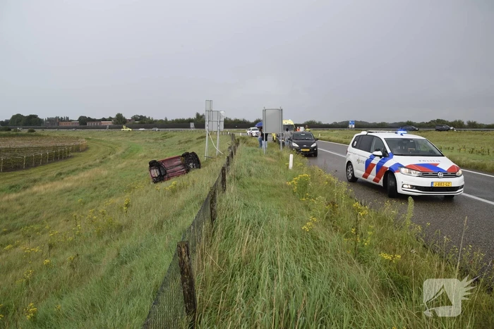 Automobilist belandt op zijkant naast afrit