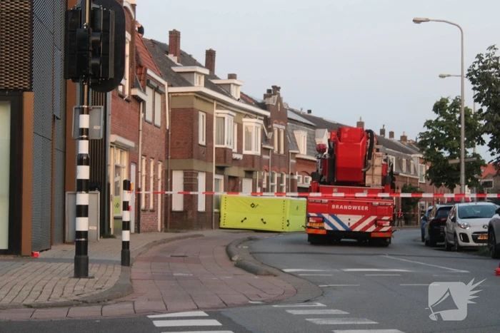 Man klimt op woning en gooit dakpannen naar hulpdiensten