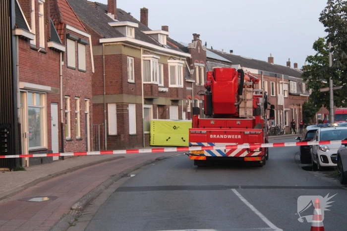 Man klimt op woning en gooit dakpannen naar hulpdiensten
