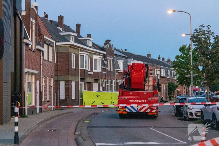 Man klimt op woning en gooit dakpannen naar hulpdiensten