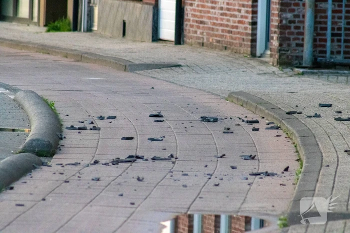 Man klimt op woning en gooit dakpannen naar hulpdiensten