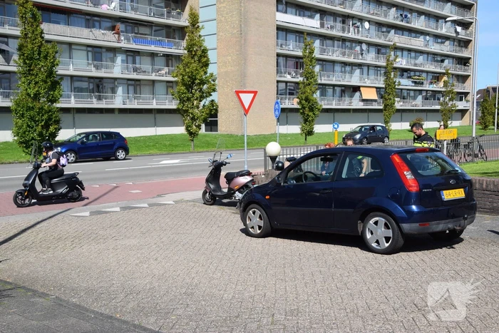 Automobilist en scooterrijder in botsing