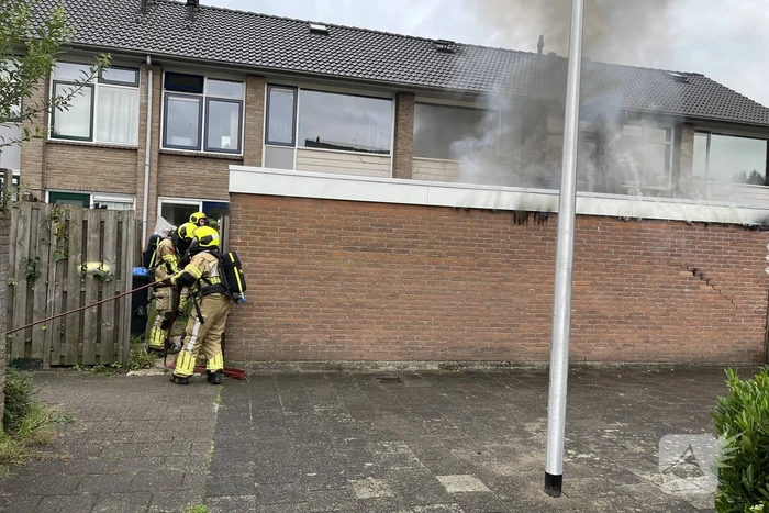 Uitslaande brand in schuur slaat over naar woning