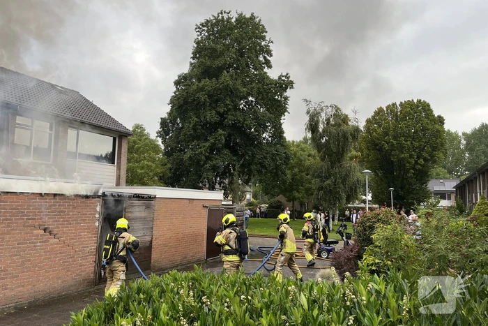 Uitslaande brand in schuur slaat over naar woning