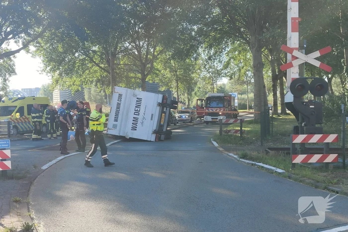 Vrachtwagen kantelt in bocht op overweg