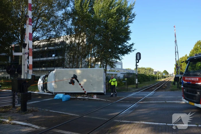 Vrachtwagen kantelt in bocht op overweg