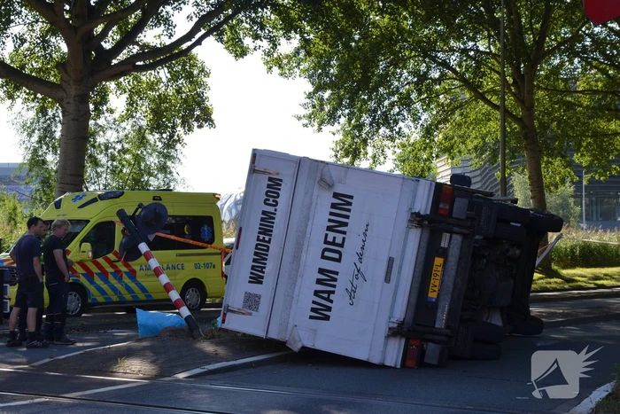 Vrachtwagen kantelt in bocht op overweg
