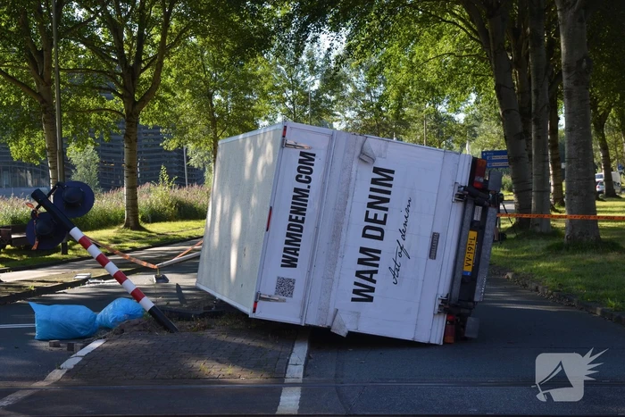 Vrachtwagen kantelt in bocht op overweg