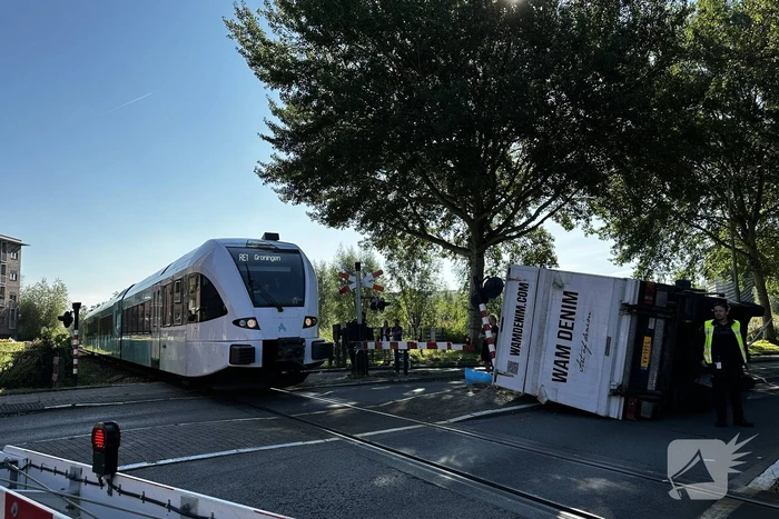 Vrachtwagen kantelt in bocht op overweg