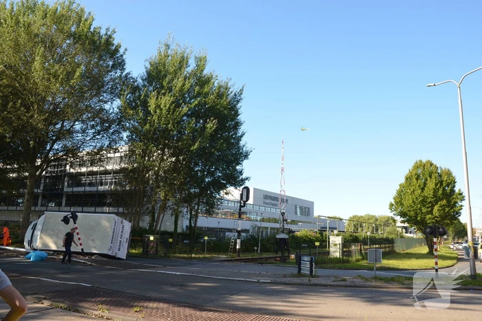 Vrachtwagen kantelt in bocht op overweg