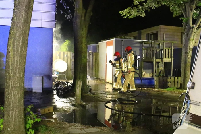 Scooter in brand tegen woning