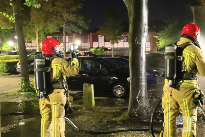 Scooter in brand tegen woning