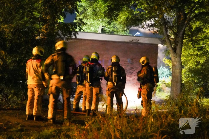 Bankstel tegen elektriciteitshuis in brand