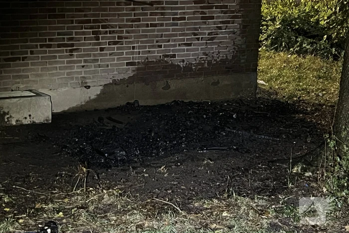 Bankstel tegen elektriciteitshuis in brand