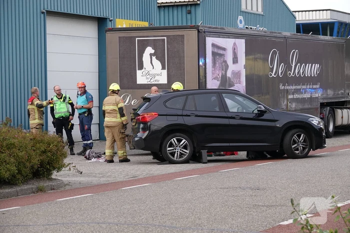 Scooterrijder bekneld onder auto