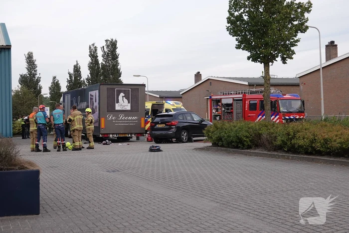 Scooterrijder bekneld onder auto