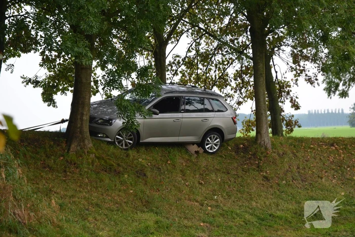 Automobilist belandt bijna onderaan dijk
