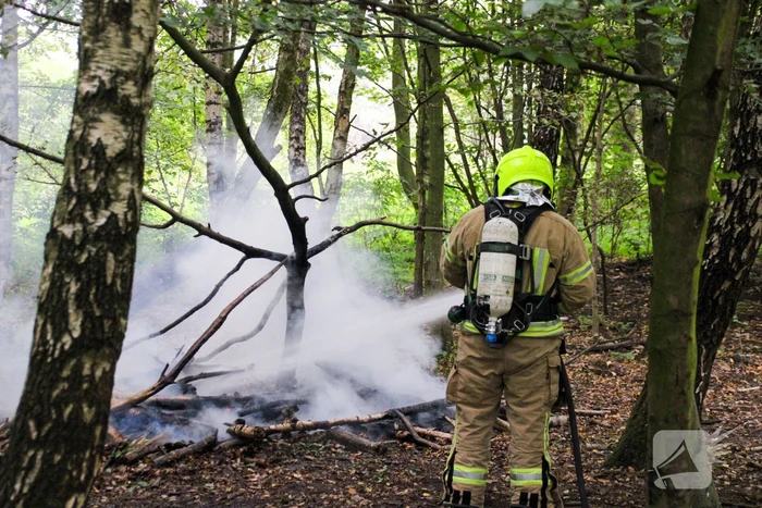 Brandweer blust kampvuur in bos