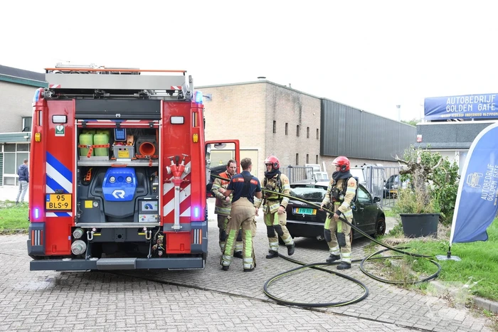 Brandweer blust brandende auto