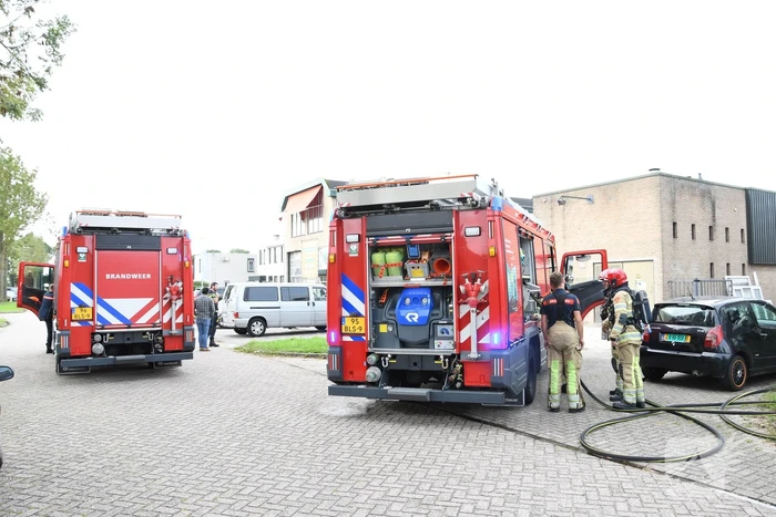 Brandweer blust brandende auto