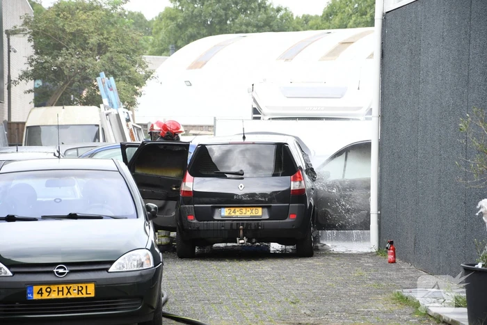 Brandweer blust brandende auto