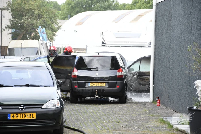 Brandweer blust brandende auto