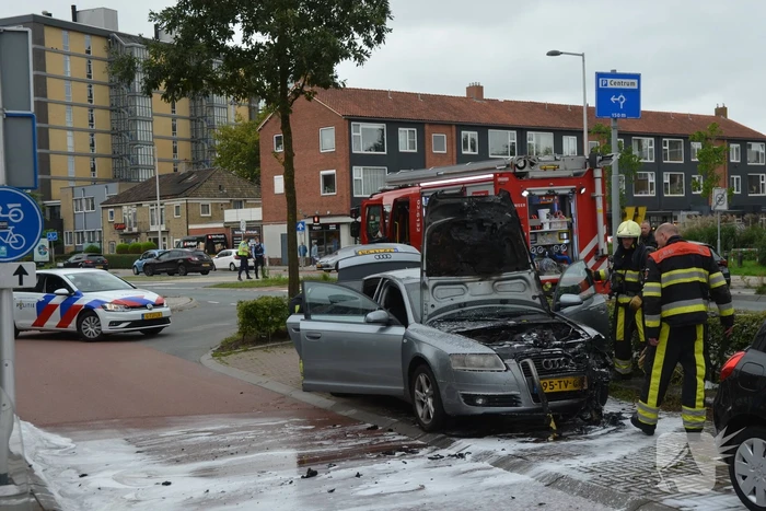 Brandweer blust brand in motorcompartiment van auto