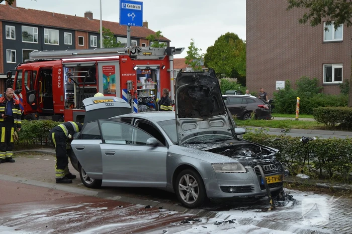 Brandweer blust brand in motorcompartiment van auto