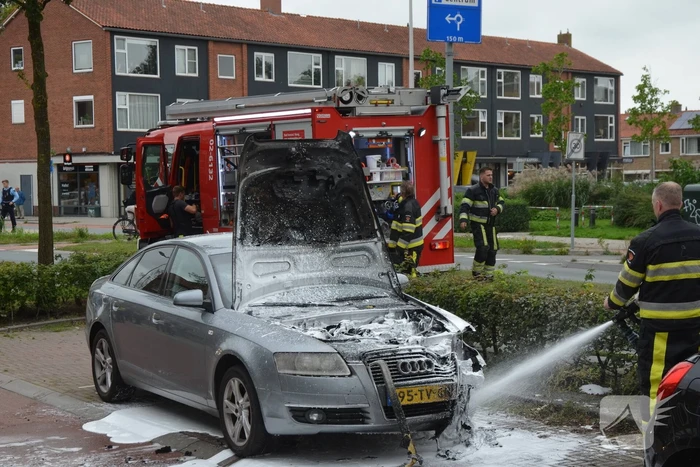 Brandweer blust brand in motorcompartiment van auto