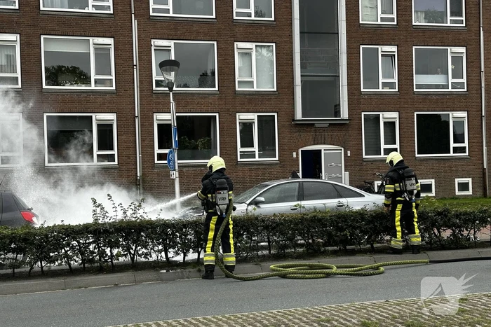 Brandweer blust brand in motorcompartiment van auto