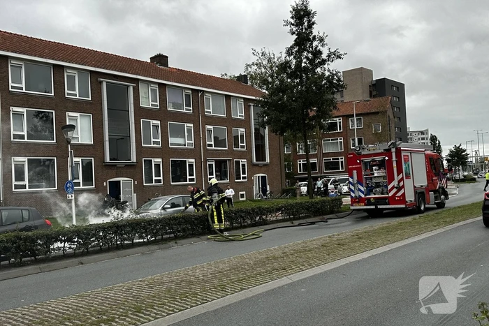 Brandweer blust brand in motorcompartiment van auto