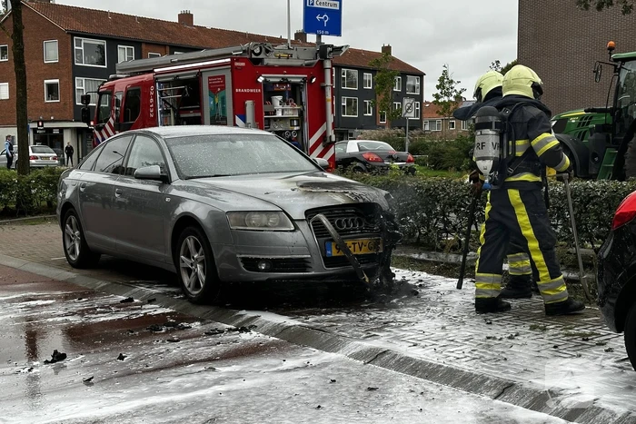 Brandweer blust brand in motorcompartiment van auto