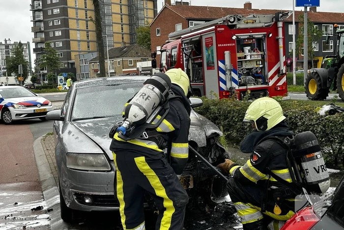 Brandweer blust brand in motorcompartiment van auto