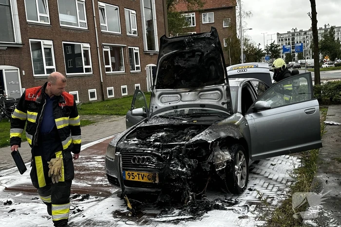 Brandweer blust brand in motorcompartiment van auto