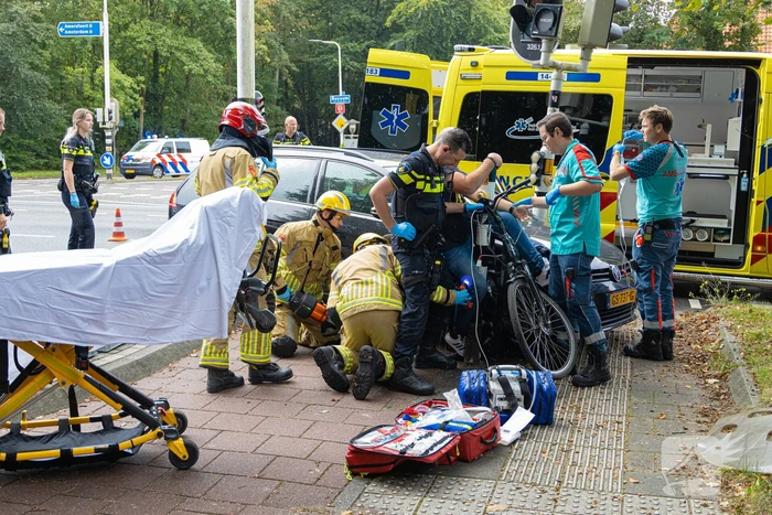 Fietser bekneld tussen auto en paal