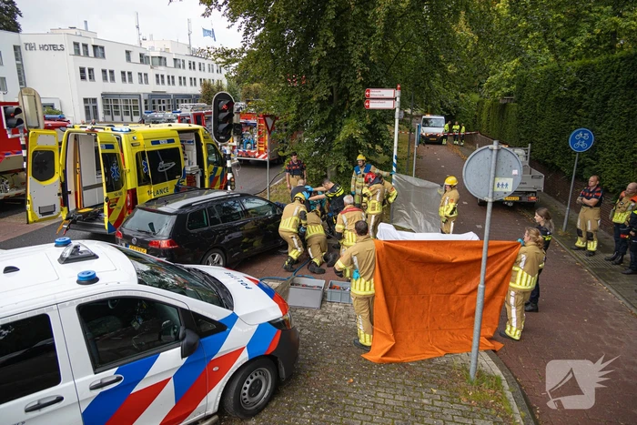Fietser bekneld tussen auto en paal