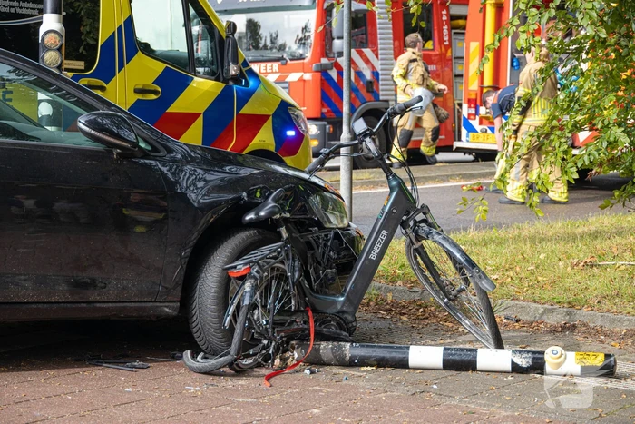 Fietser bekneld tussen auto en paal