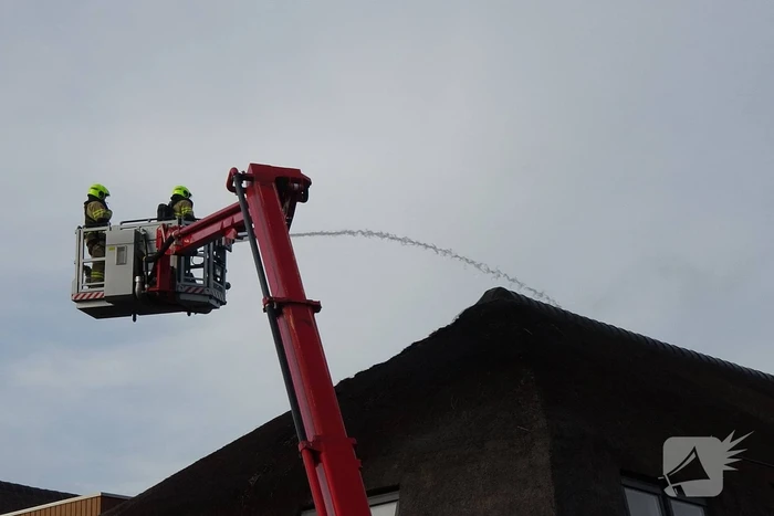 Brand op dak van appartementencomplex met rietendak