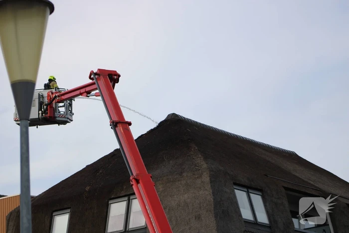 Brand op dak van appartementencomplex met rietendak