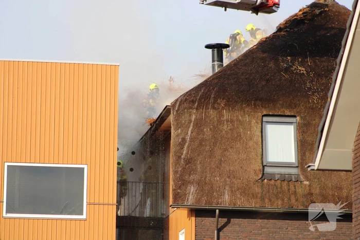 Brand op dak van appartementencomplex met rietendak