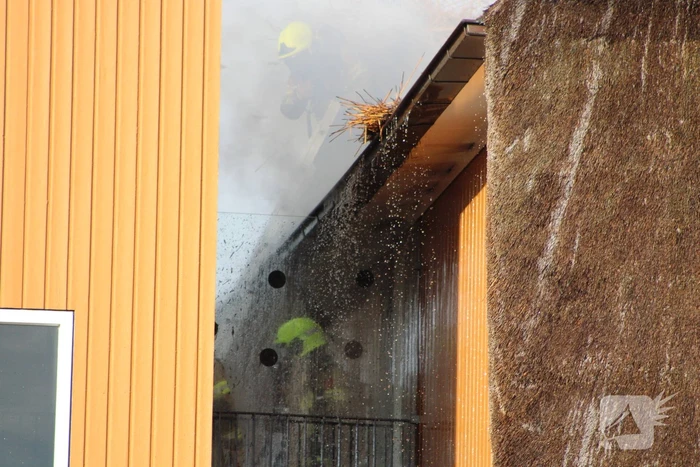 Brand op dak van appartementencomplex met rietendak