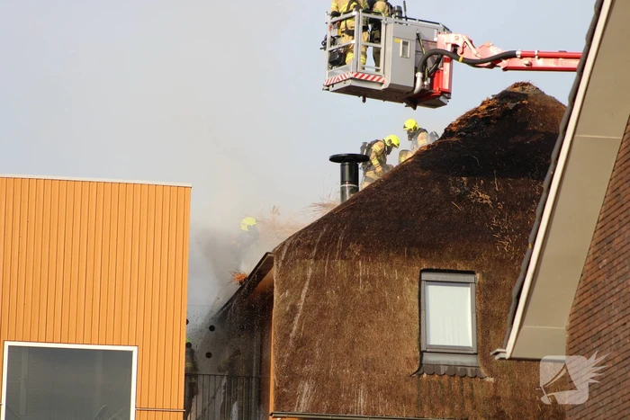 Brand op dak van appartementencomplex met rietendak