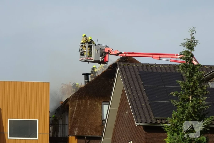 Brand op dak van appartementencomplex met rietendak