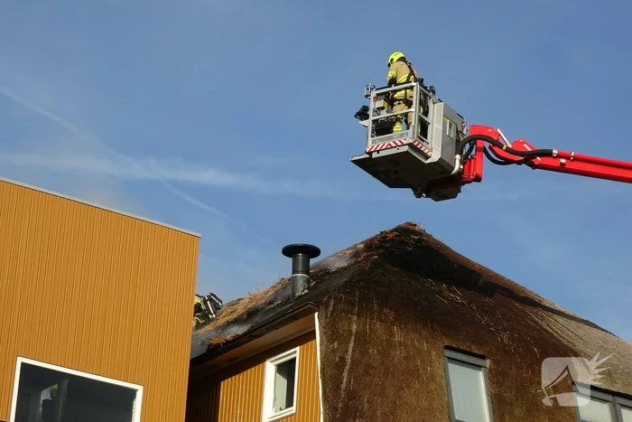 Brand op dak van appartementencomplex met rietendak