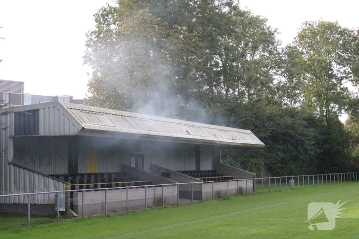 Brandweer blust brand onder voetbaltribune