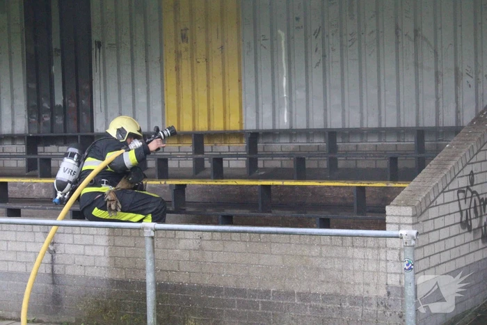 Brandweer blust brand onder voetbaltribune