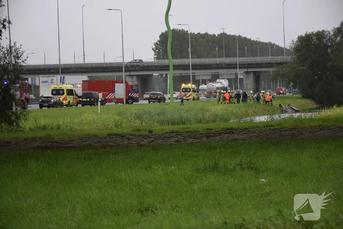 Auto raakt te water naast snelweg